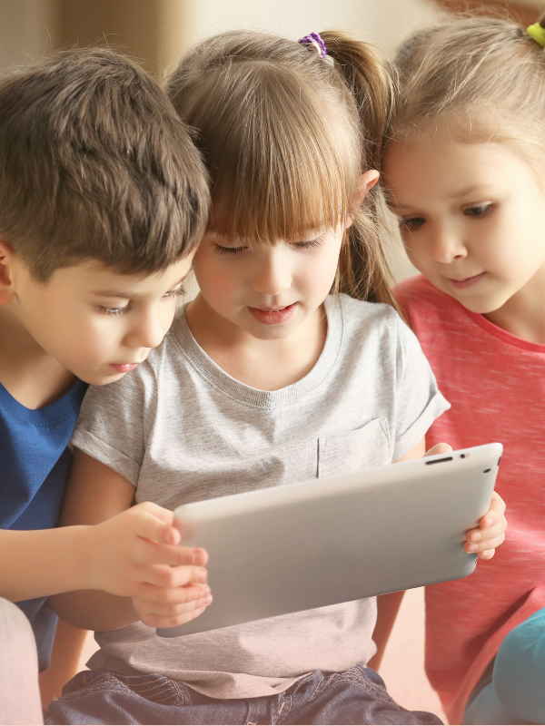 Group of preschool children using a tablet together, reflecting screen time rules by age