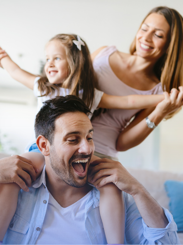 Happy family enjoying time together at home, representing positive summer routines for kids.