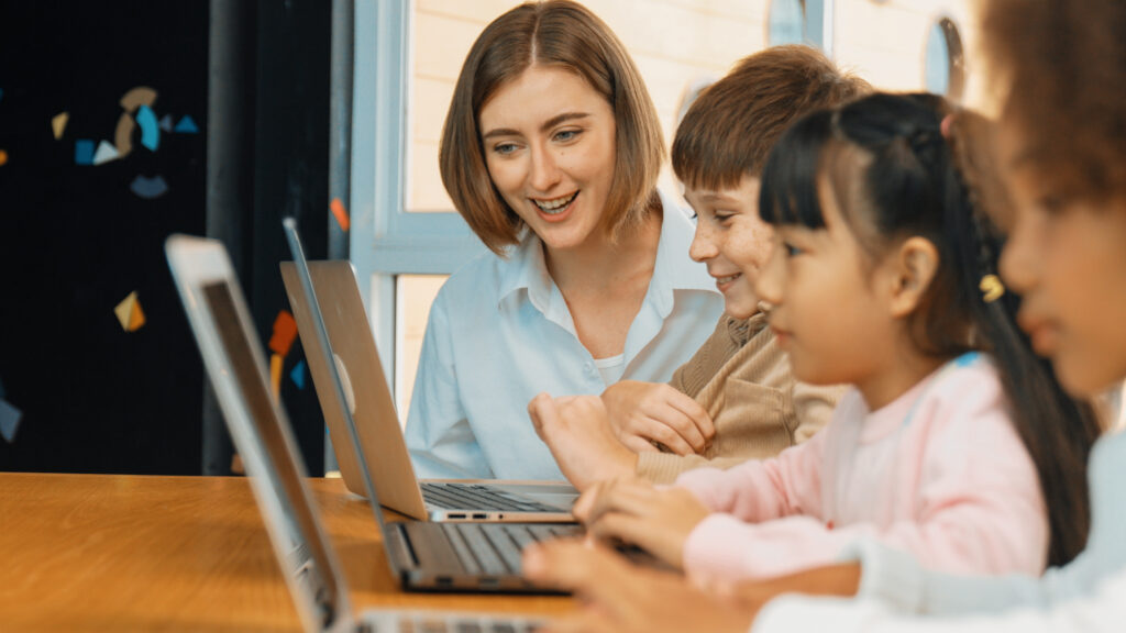 Children working on laptops, reflecting how to teach digital safety to kids through guided use and adult support.