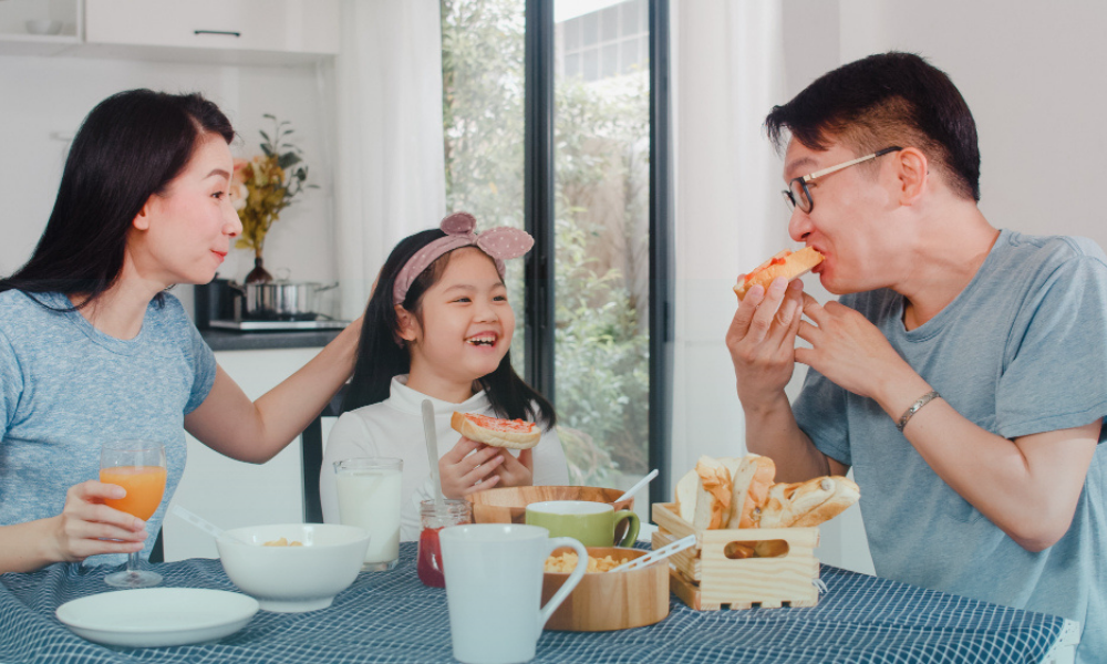 Family enjoying a relaxed meal together at home, a simple stress relief tip for overwhelmed parents.